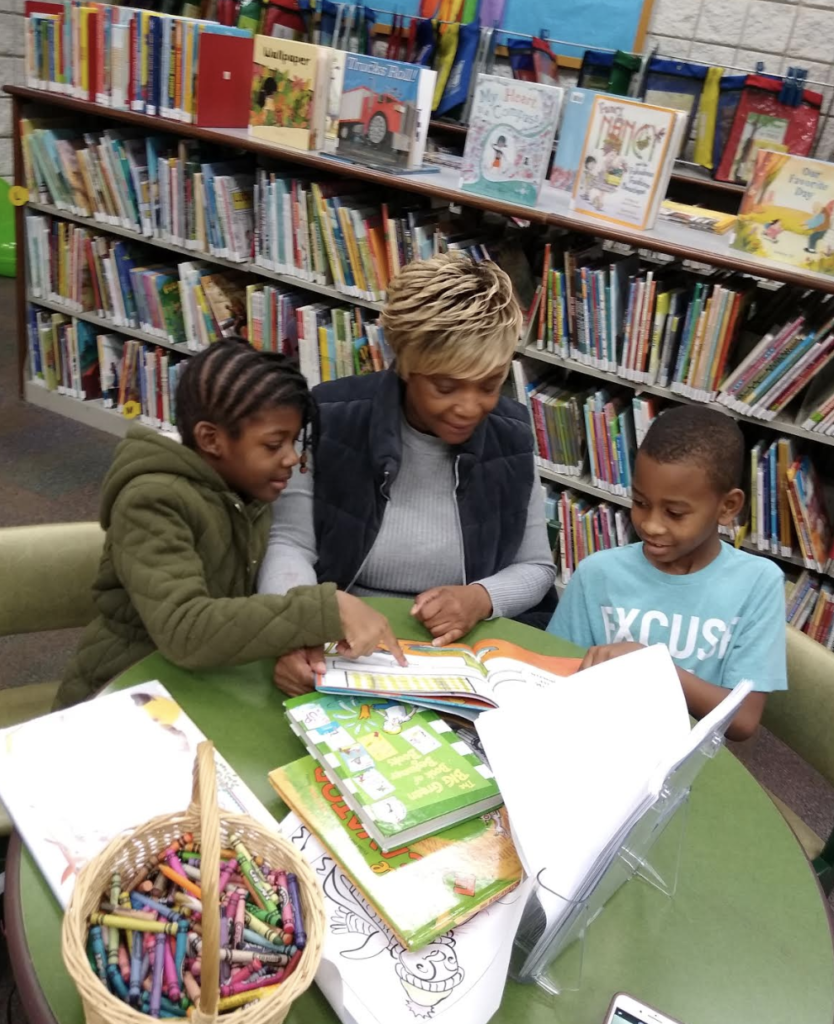 Trudy Jackson helping kids with homework at a library.