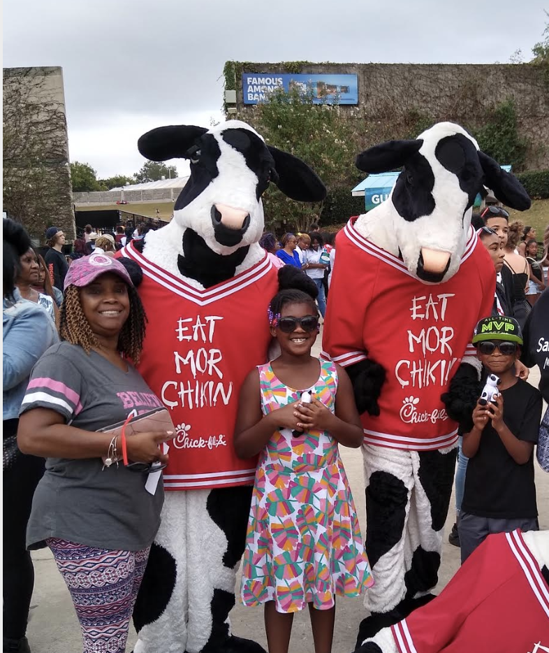 Trudy Jackson posing with kids at a fair outside.